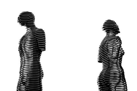 Abstract metal sculptures of human forms in black and white — figurative art beyond literal realism