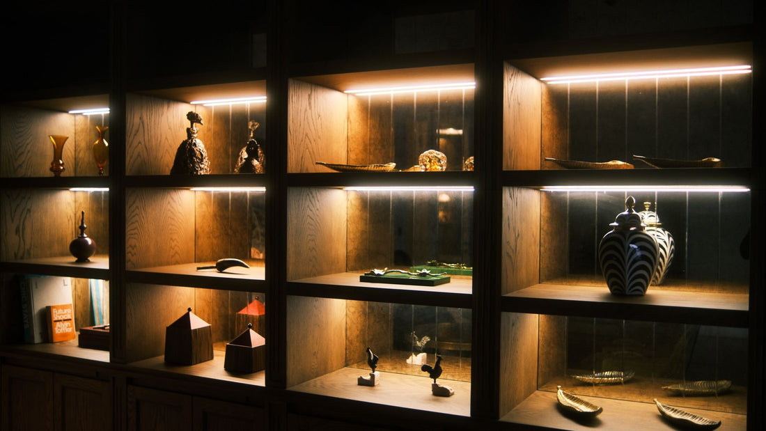 Warmly lit wooden shelves holding ceramic sculptures and vessels in a home interior