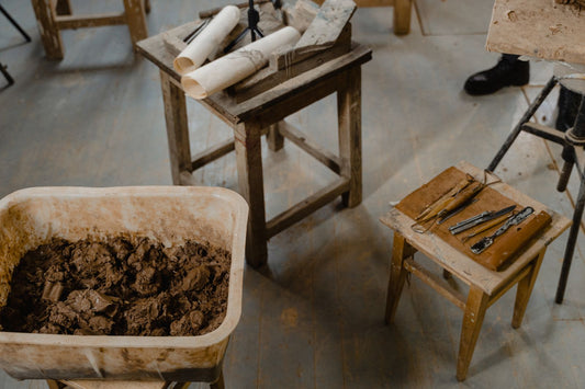 Overhead view of a sculpture studio with clay, hand tools and wooden work tables