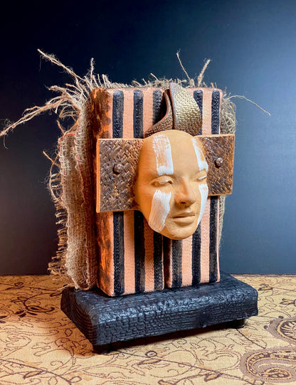 Decorative mask with striped patterns on a dark background