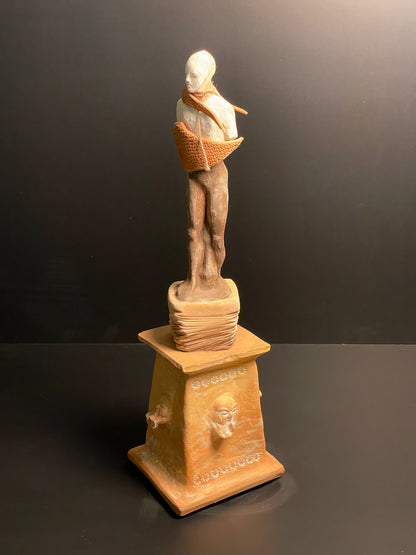 Statue on a pedestal against a dark background