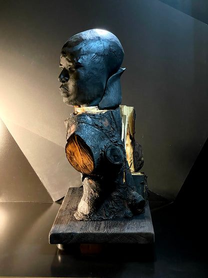 Statue of a man on a wooden block with a dark background