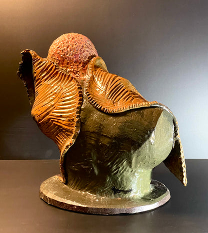 Decorative sculpture of a bird with a textured body on a dark background