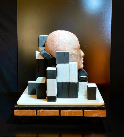 Abstract sculpture of a face made from geometric blocks on a dark background